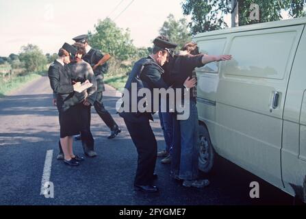 COUNTY TYRONE, VEREINIGTES KÖNIGREICH - SEPTEMBER 1980. RUC, Royal Ulster Constabulary, Polizei auf Fahrzeug halten und suchen während der Unruhen, Nordirland, 1980er Jahre Stockfoto