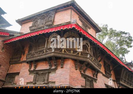 Kunstvoll verzierte, reich geschnitzte Balkon eines alten Hauses am Durbar Square, Kathmandu, Nepal. Stockfoto