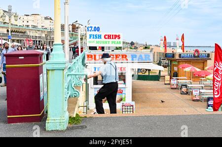 Brighton UK 28. Mai 2021 - Besucher genießen einen warmen Tag an der Strandpromenade von Brighton, während die Menschen zum Feiertagswochenende kommen, wobei für die nächsten Tage im Vereinigten Königreich mit Temperaturen von über 20 Grad im Südosten ein heißeres, sonniges Wetter prognostiziert wird : Credit Simon Dack / Alamy Live News Stockfoto