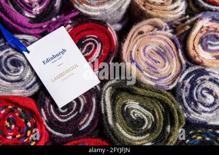 Foto von Rollen aus Tartanwolle. Seit 1437 ist ein Etikett mit einem blauen Band mit der Aufschrift Edinburgh Lambswool Collection angebracht Stockfoto