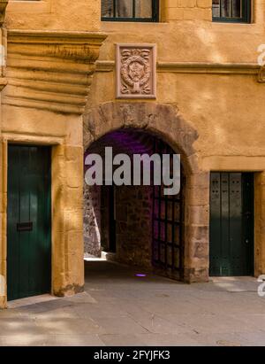 Ein Foto vom Eingang zum Patrick Geddes Centre in Edinburgh. Es gibt zwei grüne Türen und einen Torbogen. Über dem Bogen befindet sich ein Wappen. Stockfoto