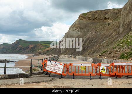 Warnschild, das darauf hinweist, dass der Küstenweg der Promenade wegen der Gefahr für die Öffentlichkeit durch Steinschläge gesperrt ist. West Bay, Dorset, England, Großbritannien Stockfoto