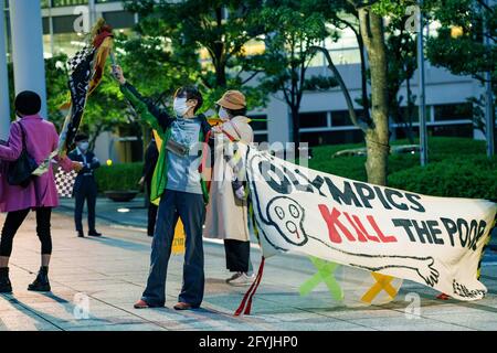 29. Mai 2021: Protestierende Wellen Band mit mehreren Sprachen geschrieben, während ein "Olympics Kill the Poor" Zeichen während des Protests gegen die Olympischen Spiele 2020/2021 in Tokio Stockfoto