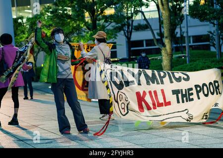 29. Mai 2021: Protestierende Wellen Band mit mehreren Sprachen geschrieben, während ein "Olympics Kill the Poor" Zeichen während des Protests gegen die Olympischen Spiele 2020/2021 in Tokio Stockfoto