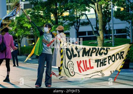 29. Mai 2021: Protestierende Wellen Band mit mehreren Sprachen geschrieben, während ein "Olympics Kill the Poor" Zeichen während des Protests gegen die Olympischen Spiele 2020/2021 in Tokio Stockfoto