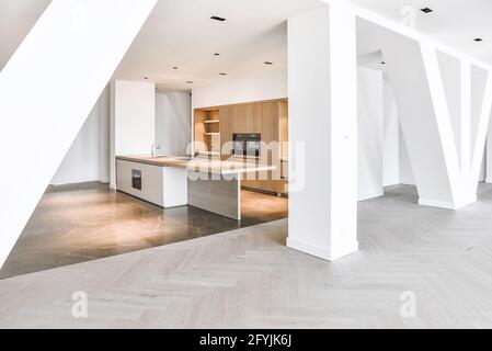 Interieur der Penthouse-Wohnung mit Parkett und Marmorboden und Minimalistische Küche mit Holzschränken Stockfoto