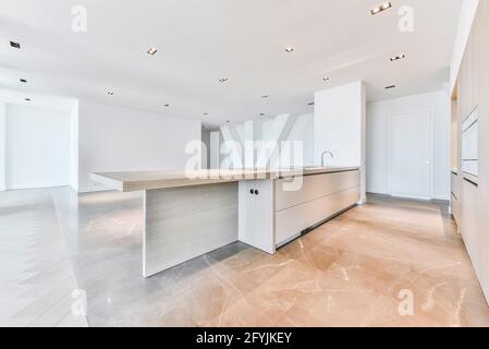 Interieur der Penthouse-Wohnung mit Parkett und Marmorboden und Minimalistische Küche mit Holzschränken Stockfoto