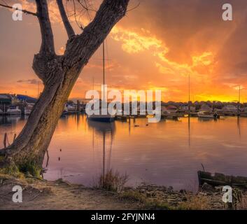 Boote, die nach einem Sturm bei Sonnenuntergang in einem Hafen festgemacht wurden, Venetien, Italien Stockfoto