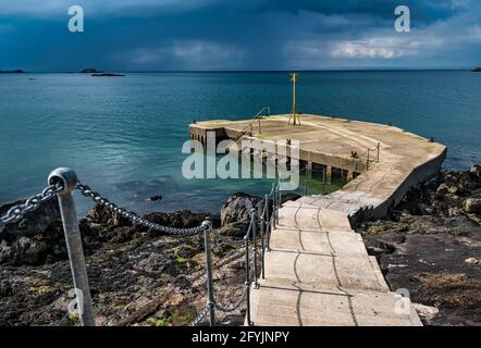 Alte Pier und Navigationsmarkierung an sonnigen Tagen mit Sturmwolken über Firth of Forth, North Berwick, East Lothian, Schottland, Großbritannien Stockfoto