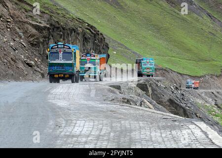 LEH, INDIEN - 1. SEPTEMBER 2014 : Lastwagen, die Waren transportieren, passieren den Zojila Pass, einen Hochgebirgspass zwischen Srinagar und Leh bei 11575 Fuß. Stockfoto