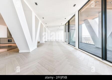 Penthouse-Interieur des Studios mit Glaswänden und Terrasse Blick auf das Stadtbild im Sonnenlicht Stockfoto