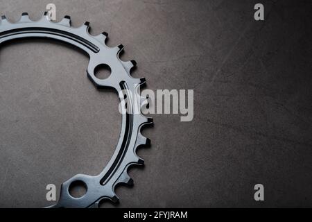 Schwarzer Stern des schmalen breiten Fahrrad-Pleuelsystems. Ein Zahnmuster eines fahrenden Fahrradstars auf schwarzem Hintergrund. Dunkle Taste, Draufsicht Stockfoto