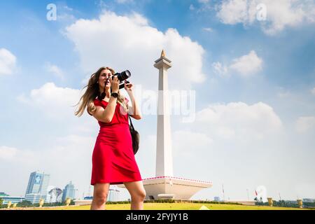 Frau fotografieren beim Sightseeing am National Monument in Jakarta, Indonesien Stockfoto