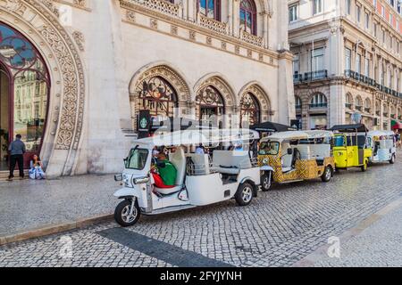 LISSABON, PORTUGAL - 10. OKTOBER 2017: Tuk Tuks vor dem Rossio Bahnhof in Lissabon, Portugal Stockfoto