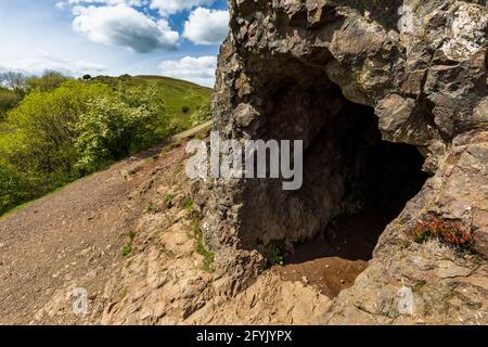 Der Eingang zur Clutter’s Cave in den Malvern Hills mit British Camp im Hintergrund, Worcestershire, England Stockfoto