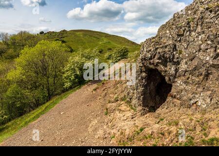Der Eingang zur Clutter’s Cave in den Malvern Hills mit British Camp im Hintergrund, Worcestershire, England Stockfoto