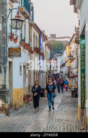 OBIDOS, PORTUGAL - 11. OKTOBER 2017: Touristen in einer engen Gasse im Dorf Obidos. Stockfoto