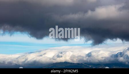 Antenne, Drohne, dunkelgraue und weiße Wolken auf blauem Himmel Hintergrund, Raum. Konzept der schweren Wolkenlandschaft über Bergen. Abstrakt dramatisches Schlechtwetter, Thund Stockfoto