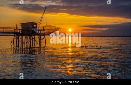 Charente Maritime, Frankreich, mit Küstenfischerhütte auf Pfählen und Sonnenuntergang am Ufer der Gironde bei La Rochelle, Frankreich Stockfoto