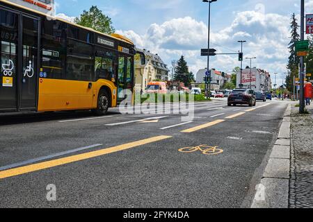 Berlin, Deutschland - 8. Mai 2021: Straßenszene mit temporär bemaltem Radweg in Berlin. Der Fokus liegt auf dem gelben Fahrradsymbol auf dem Asphalt. Stockfoto