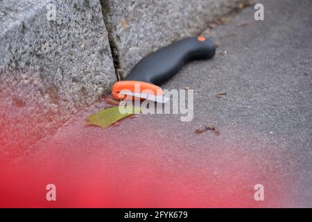 Hamburg, Deutschland. Mai 2021. Ein scheinbar beschädigtes Messer liegt in einem Spurmarkierer am abgesperrten Tatort. Bei einem Polizeieinsatz in Hamburg-Winterhude wurde am Freitag ein Mann von Beamten getötet. Der unbekannte Mann hatte zuvor Autos gestoppt, sie beschädigt und die Fahrer mit einem Messer bedroht, sagte eine Polizeisprecherin. Quelle: Jonas Walzberg/dpa/Alamy Live News Stockfoto