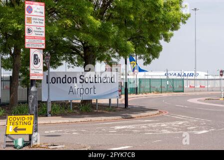 COVID 19 Teststation Schild am London Southend Airport, Essex, Großbritannien. Mit Flughafeneingangsschild und Ryanair Boeing 737-Flugzeug Stockfoto