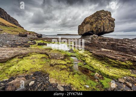 Große Felsen und Dinosaurier-Fußabdrücke in Staffin Bay auf der Isle of Skye. Stockfoto