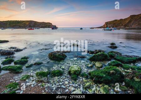 Ein herrlicher Sonnenaufgang in der malerischen Lulworth Cove in Dorset. Stockfoto