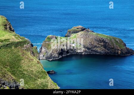 Die kleine Insel Carrickarede an der Causeway Coast ist durch die berühmte Seilbrücke Carrick-a-Rede mit dem Festland verbunden. Eine Location für Game of Thrones. Stockfoto