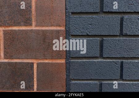 Nahaufnahme von dunkelorangenen und schwarzen Backsteinwänden, die miteinander verbunden sind. Zwei miteinander verbundene Wände. Stockfoto