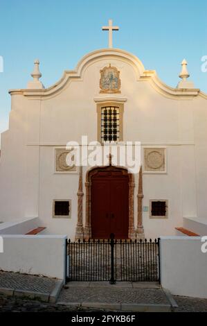 Portugal, Sines. Kirche Nossa Senhora das Salas. Die Kapelle wurde auf Initiative von Vasco da Gama erbaut, neben dem Ort, an dem sich eine Einsiedelei befand, die an die Rettung der Prinzessin Fatassa erinnert. Der ursprüngliche Tempel stammt aus dem 15. Jahrhundert, obwohl er im 16. Jahrhundert modifiziert wurde. Gesamtansicht der Hauptfassade. Bezirk Setúbal. Stockfoto