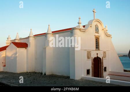 Portugal, Sines. Kirche Nossa Senhora das Salas. Die Kapelle wurde auf Initiative von Vasco da Gama erbaut, neben dem Ort, an dem sich eine Einsiedelei befand, die an die Rettung der Prinzessin Fatassa erinnert. Der ursprüngliche Tempel stammt aus dem 15. Jahrhundert, obwohl er im 16. Jahrhundert modifiziert wurde. Allgemeiner Blick nach draußen. Bezirk Setúbal. Stockfoto