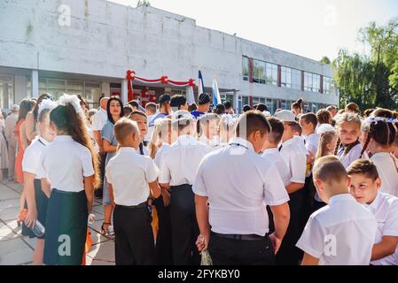 Kerch Russland - 1. September 2020 - Kinder gehen zur Schule, erste Glocke, Kinder in Schuluniformen, Lehrer und Eltern im Hintergrund in der Nähe des sc Stockfoto