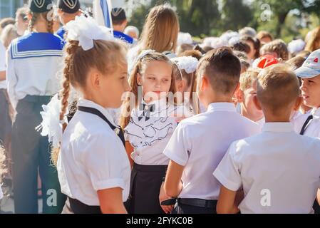 Kerch Russland - 1. September 2020 - Kinder gehen zur Schule, erste Glocke, Kinder in Schuluniformen, Lehrer und Eltern im Hintergrund in der Nähe des sc Stockfoto