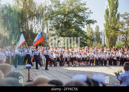 Kerch Russland - 1. September 2020 - Kinder gehen zur Schule, erste Glocke, Kinder in Schuluniformen, Lehrer und Eltern im Hintergrund in der Nähe des sc Stockfoto