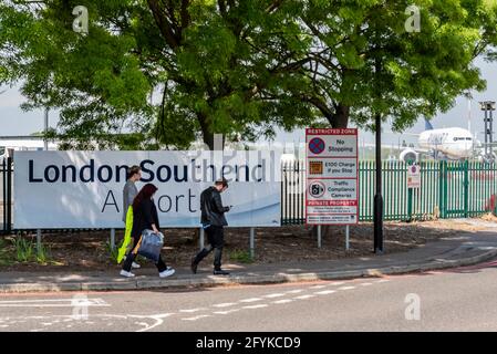 Flugreisende, die am Londoner Flughafen Southend in Essex, Großbritannien, mit einem flugbereiten Ryanair-Flugzeug ankommen. Erwachsene gehen am Flughafeneingangsschild vorbei Stockfoto