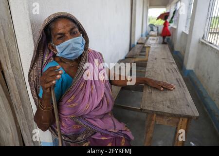 Dhamakhali, Indien. Mai 2021. Eine ältere Frau, die eine Gesichtsmaske trägt, sitzt in einer Schule, die in der Folge zu einem Zyklonzentrum für die Dorfbewohner wurde.Menschen aus verschiedenen Bezirken sind stark vom Superzyklon "YaaS" betroffen. Flusswälle sind gebrochen und mehrere Dörfer überschwemmt. Salzwasser ist in die Dörfer eingedrungen und dadurch sind Fische aus Teichwasser tot. Die Menschen stehen vor vielen Schwierigkeiten. (Foto von JIT Chattopadhyay/SOPA Images/Sipa USA) Quelle: SIPA USA/Alamy Live News Stockfoto