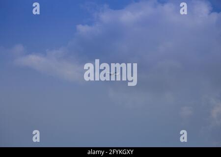 Propellerflugzeug von der Sonne gegen einen blauen Himmel beleuchtet Mit weißen Wolken und Baum - in Bewegung Stockfoto