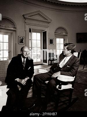 3. August 1961 Präsident John F. Kennedy (im Schaukelstuhl) trifft sich mit dem Botschafter der Vereinigten Staaten bei den Vereinten Nationen Adlai E. Stevenson im Oval Office im Weißen Haus, Washington, D.C.. Er wuchs in Bloomington, Illinois, auf und war Mitglied der Demokratischen Partei.[1] in den 1930er und 1940er Jahren war er in zahlreichen Positionen in der Bundesregierung tätig, darunter in der Agricultural Adjustment Administration, der Federal Alcohol Administration, dem Department of the Navy und dem State Department. 1945 war er Mitglied des Ausschusses, der die Vereinten Nationen gegründet hat. Stockfoto