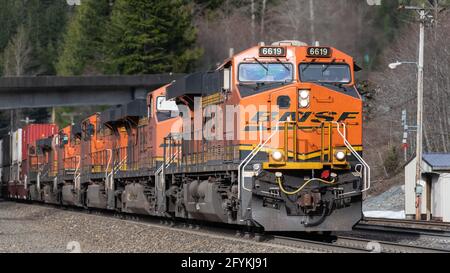 Scenic, WA, USA - 04. April 2019; EIN intermodaler BNSF-Güterzug fährt hinter sechs Triebwerken westwärts durch die Washington Cascades Stockfoto