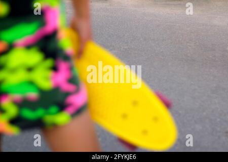 Unschärfe abstrakt leuchtend gelb bunten Sport Hintergrund. Skate Penny Board. Trendiger, flippiger Stil. Stilvoller Jugendkultur-Hintergrund. Nicht fokussiert. Stockfoto