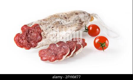Spanische Wurst longaniza ganz und Scheiben und zwei Kirschtomaten isoliert auf weißem Hintergrund. Getrocknete Longanisa-Salami aus Schweinefleisch und Gewürzen Stockfoto