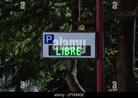 BURGOS, SPANIEN - 24. Mai 2021: Parkplatzschild mit grünem Neonschild 'LIBRE' (KOSTENLOS) Stockfoto