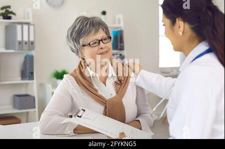 Glückliche ältere Frau im Gespräch mit ihrer Krankenschwester oder ihrem Arzt während Ihr Besuch im Krankenhaus Stockfoto