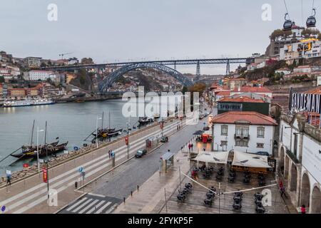 PORTO, PORTUGAL - 18. OKTOBER 2017: Dom Luis Brücke über den Douro Fluss in Porto, Portugal. Portwein-Trägerboote auf dem Fluss. Stockfoto