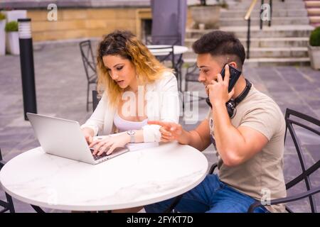Spanisches Paar Unternehmer, die mit einem Computer arbeiten - das Konzept der Teamarbeit Stockfoto