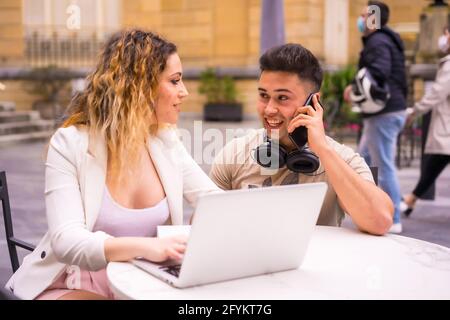 Spanisches Paar Unternehmer, die mit einem Computer arbeiten - das Konzept der Teamarbeit Stockfoto