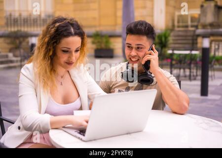 Spanisches Paar Unternehmer, die mit einem Computer arbeiten - das Konzept der Teamarbeit Stockfoto