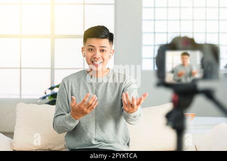 Junger Mann, der Video für eine Internet-tv-Show aufzeichnet oder Tutorial-Streaming Stockfoto