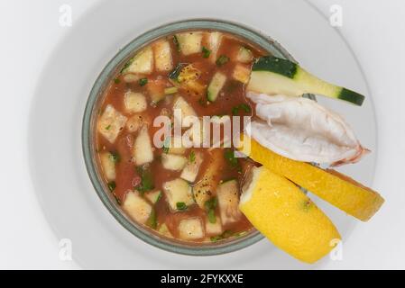 Blick von oben auf den Garnelencocktail mit in Scheiben geschnittenen Gurken und Zitrusfrüchten, serviert in großem Becher in würziger roter Sauce als Vorspeise. Stockfoto